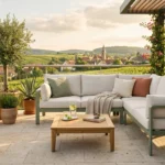 Modernes Outdoor-Sofa auf einer sonnigen Terrasse mit Teak-Tisch und mediterranen Pflanzen